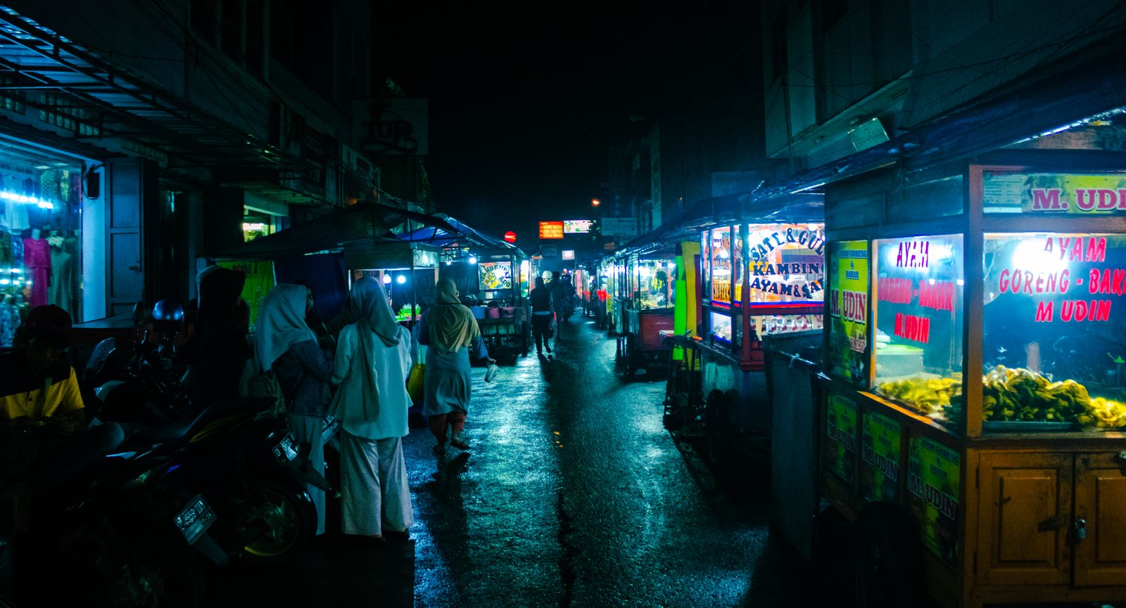 A brightly lit tourist-zone restaurant with a host waving people in