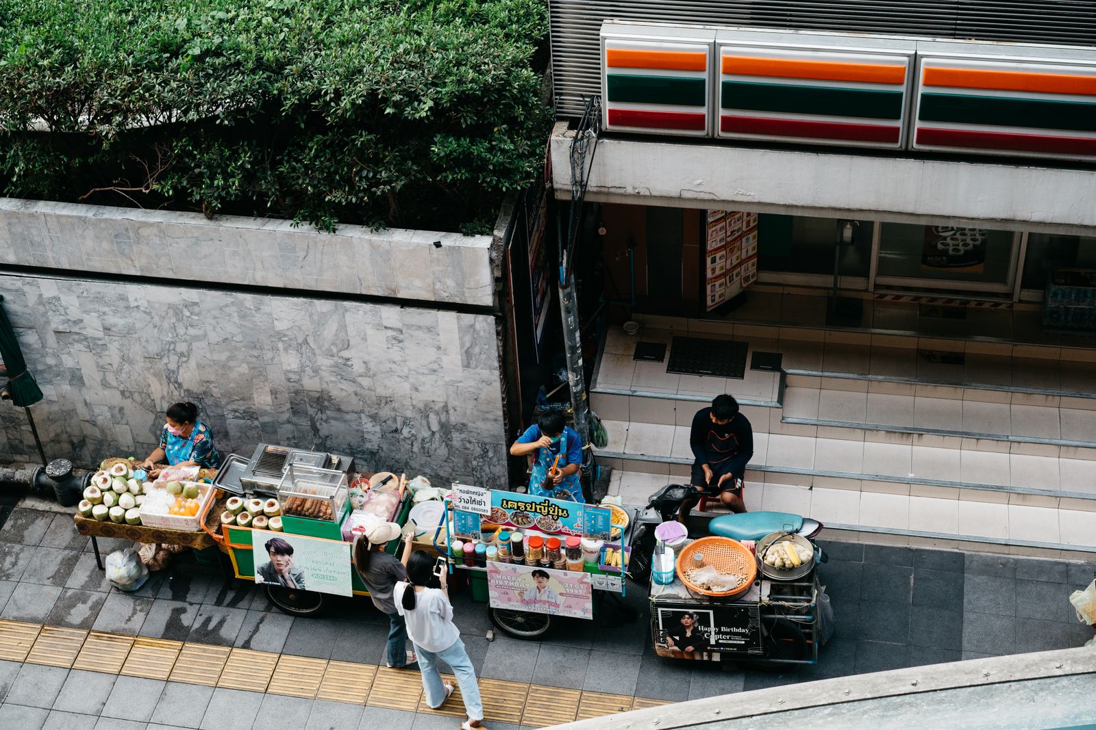 Locals at a small evening counter with drinks and small plates